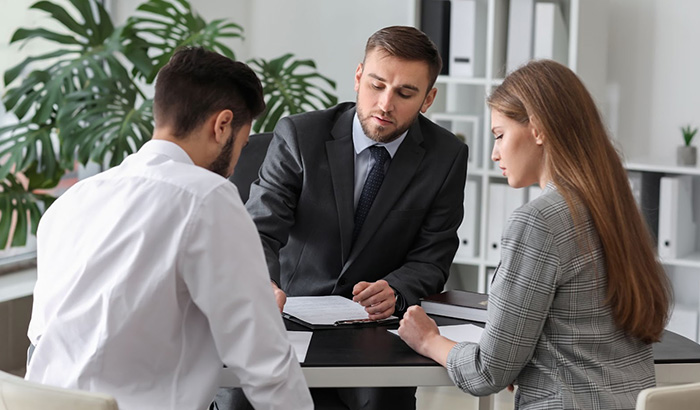 A man and woman in business attire discussing divorce consultation checklist with a divorce attorney.